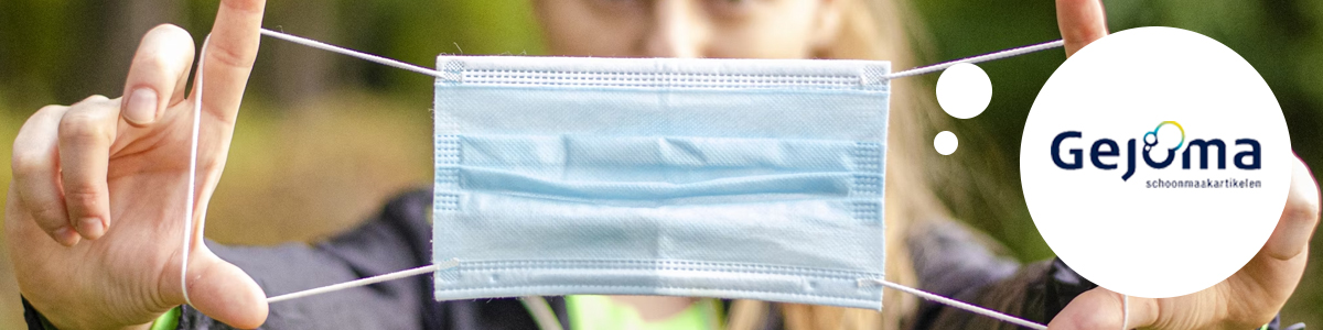 Een vrouw met een mondmasker in haar handen.