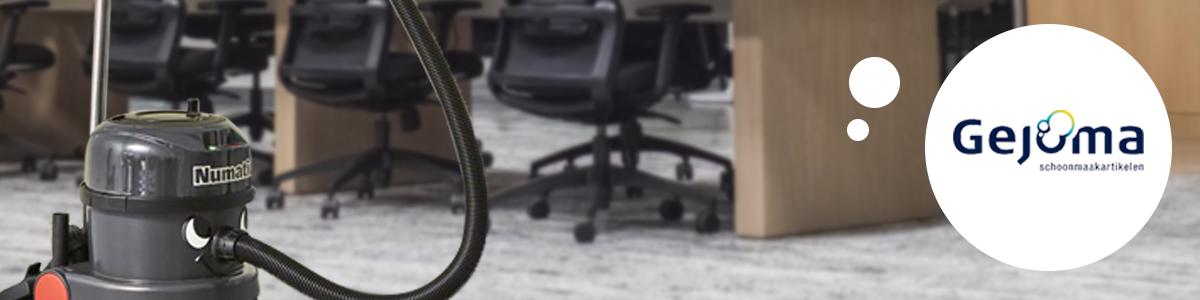 Een grijze Numatic stofzuiger die in een kantoor staat.